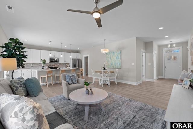 living area featuring light wood finished floors, visible vents, recessed lighting, and baseboards