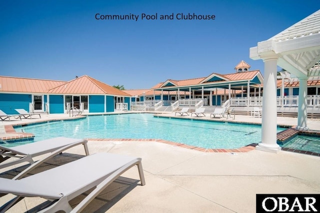 pool featuring a hot tub and a patio