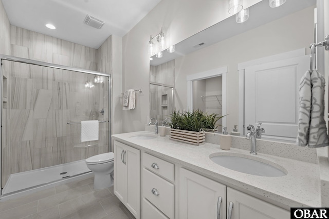 full bathroom with a sink, visible vents, a stall shower, and double vanity