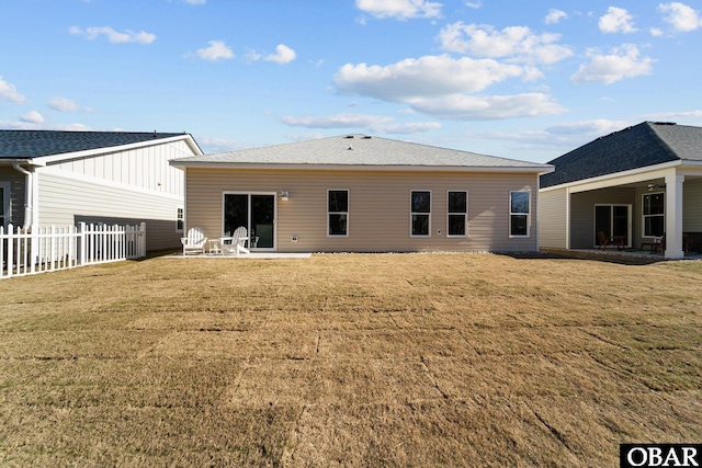 back of house with a patio, fence, a lawn, and a shingled roof