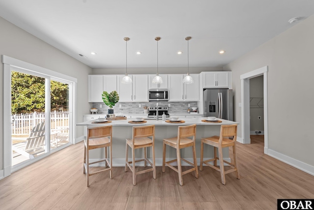 kitchen featuring light countertops, white cabinets, tasteful backsplash, and stainless steel appliances