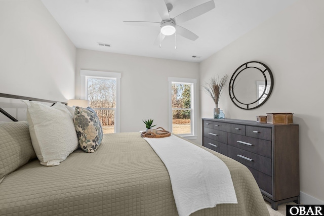 bedroom featuring visible vents, multiple windows, and ceiling fan