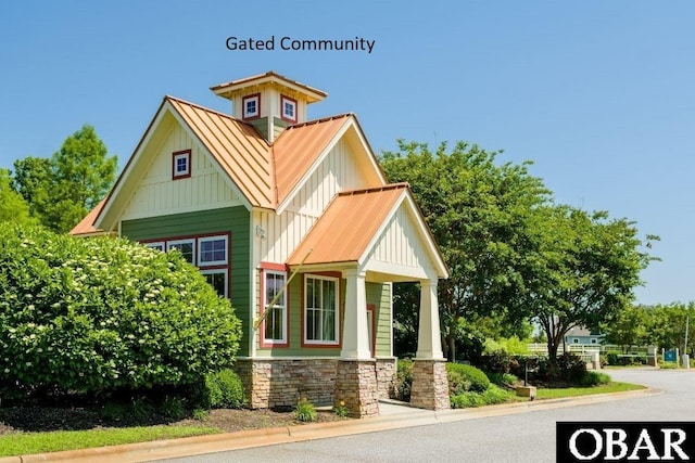 craftsman inspired home with metal roof, stone siding, board and batten siding, and a standing seam roof