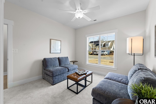 living room with visible vents, baseboards, a ceiling fan, and carpet flooring