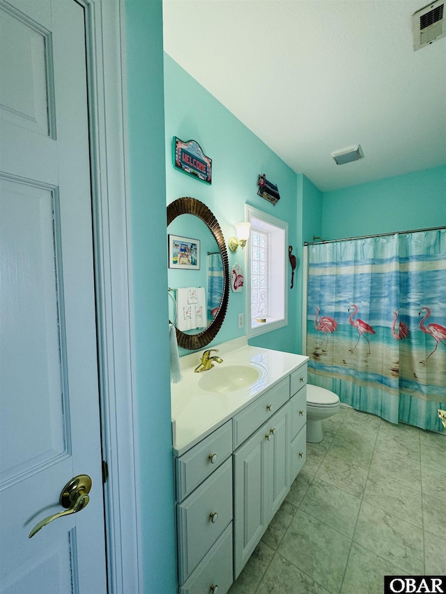 bathroom featuring toilet, vanity, and visible vents