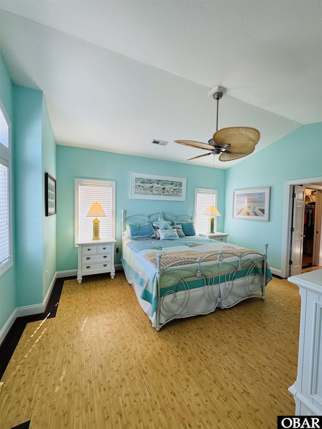 bedroom with visible vents, vaulted ceiling, ceiling fan, wood finished floors, and baseboards