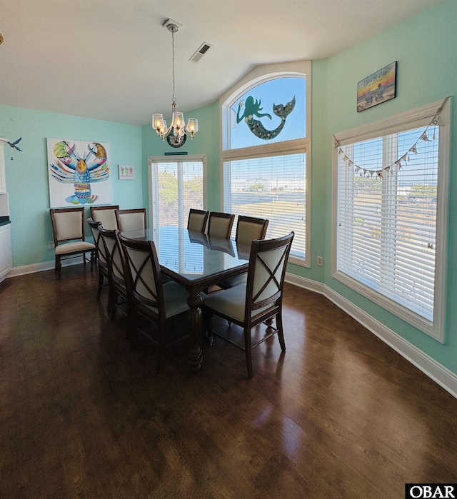 dining room featuring a chandelier, dark wood-style flooring, vaulted ceiling, and baseboards