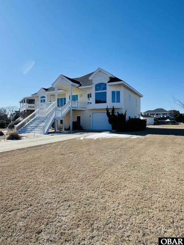 view of front of home with a porch, stairway, and an attached garage