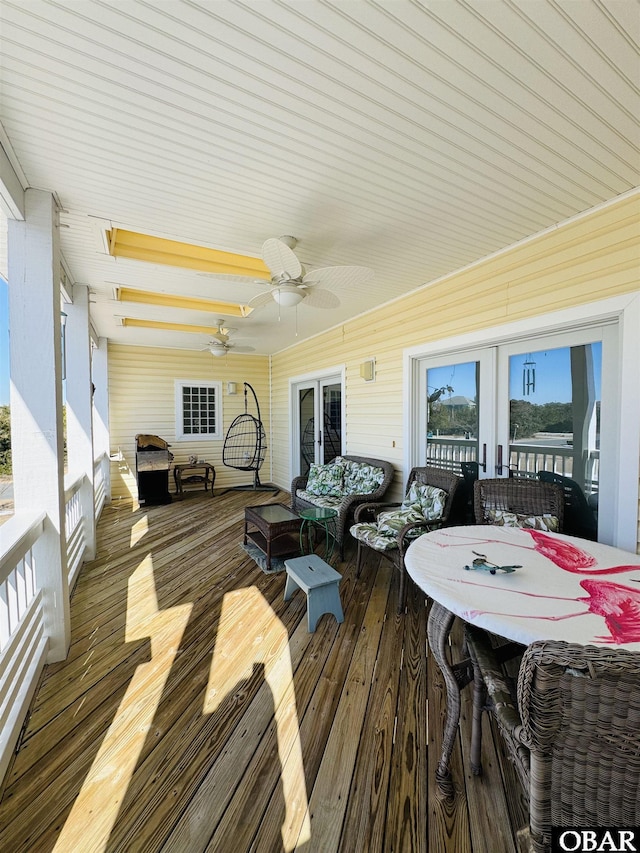 wooden deck featuring outdoor lounge area, ceiling fan, outdoor dining area, and french doors