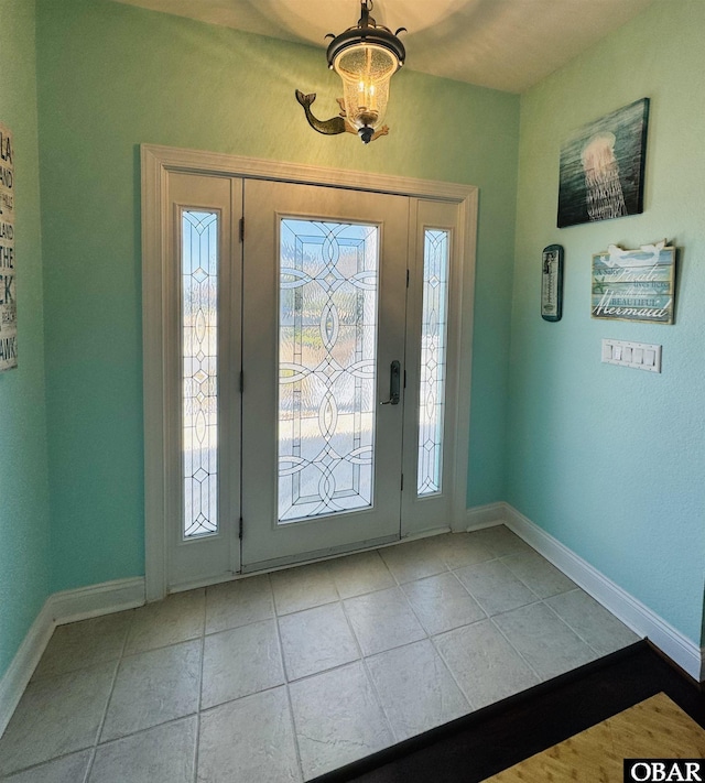 foyer featuring light tile patterned flooring and baseboards