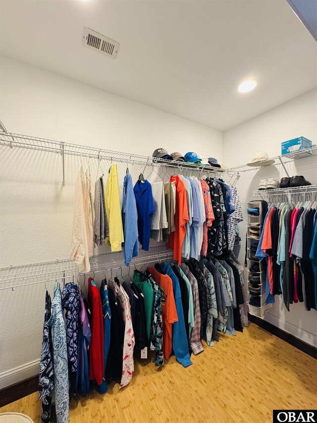 walk in closet with wood finished floors and visible vents