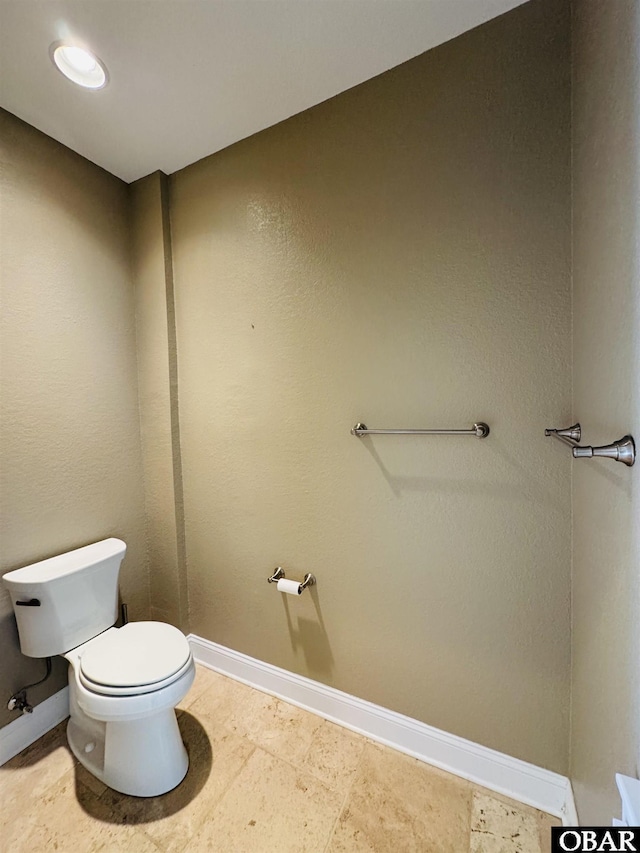 bathroom featuring toilet and baseboards