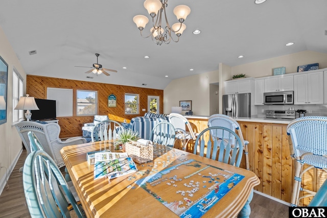 dining area with dark wood-type flooring, recessed lighting, vaulted ceiling, and ceiling fan with notable chandelier