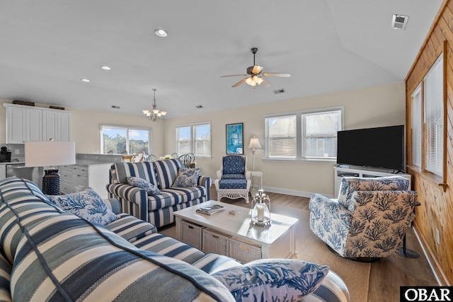 living room with light wood-style flooring, ceiling fan with notable chandelier, visible vents, and recessed lighting