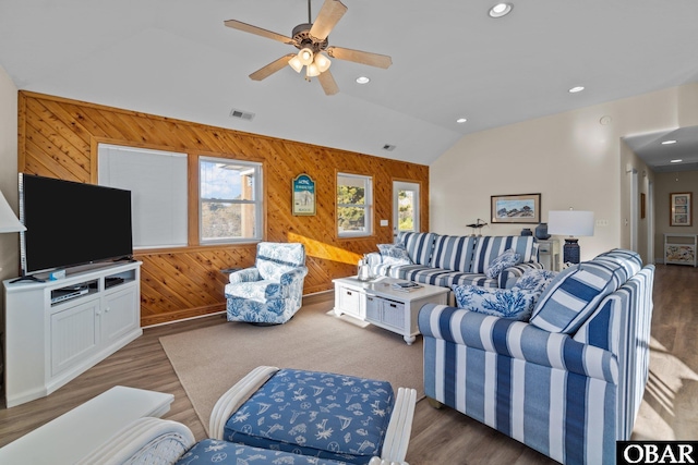 living area featuring recessed lighting, visible vents, vaulted ceiling, wooden walls, and wood finished floors