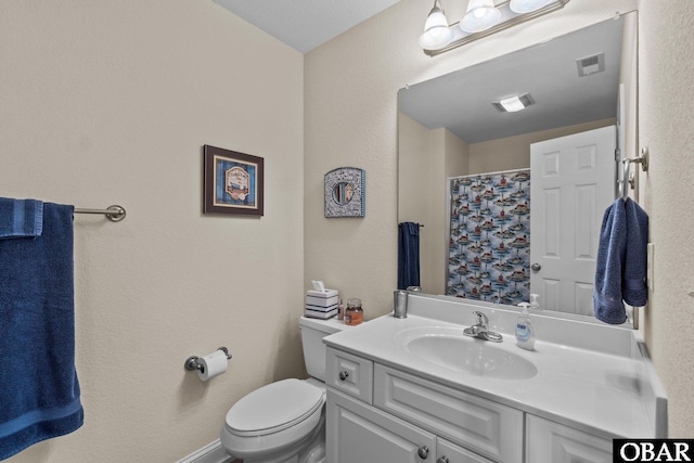 bathroom featuring toilet, vanity, and visible vents