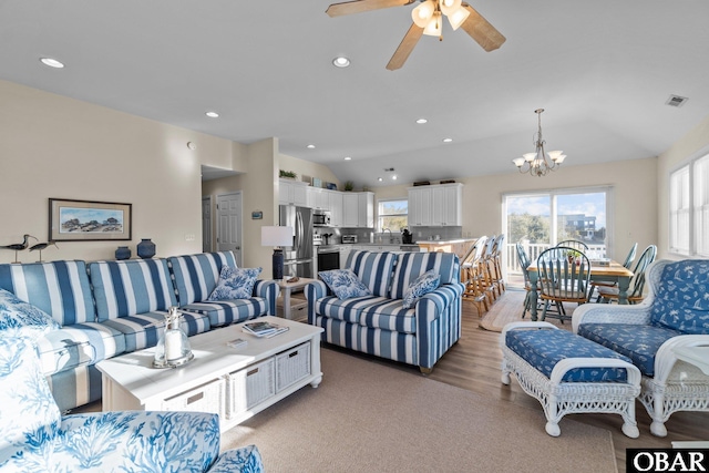 living room featuring visible vents, vaulted ceiling, a wealth of natural light, and recessed lighting