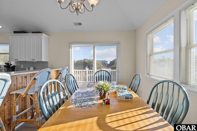 dining space with visible vents and a notable chandelier