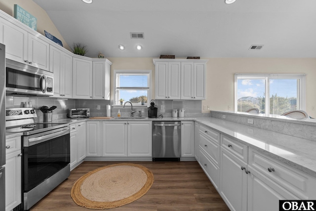 kitchen featuring appliances with stainless steel finishes, a sink, visible vents, and white cabinets