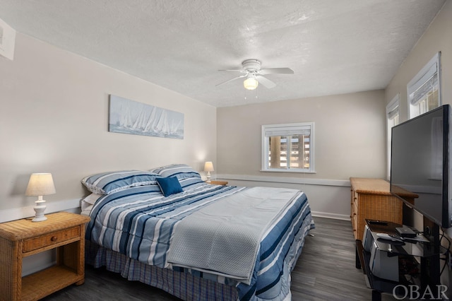 bedroom featuring a ceiling fan, dark wood finished floors, a textured ceiling, and baseboards