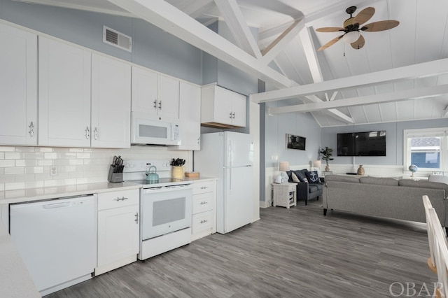 kitchen featuring open floor plan, light countertops, white appliances, and white cabinets