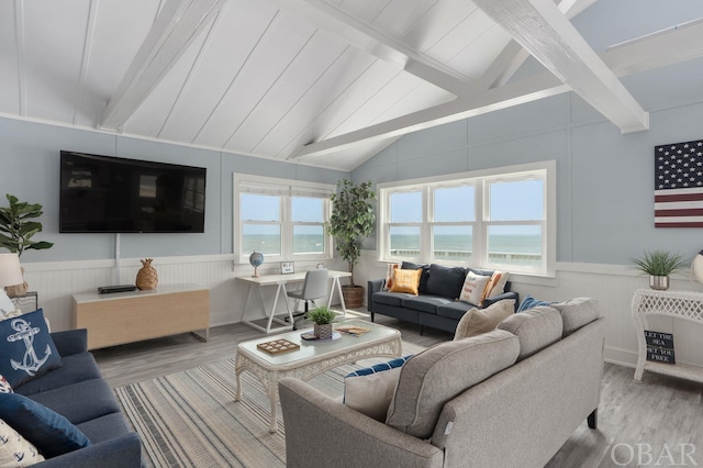 living area featuring a wealth of natural light, wainscoting, a water view, and wood finished floors