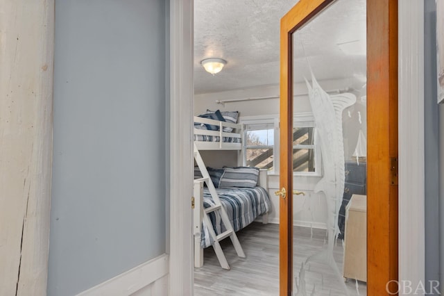 bedroom with light wood-type flooring and a textured ceiling