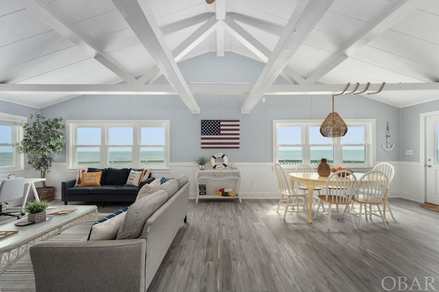 living area featuring lofted ceiling with beams, wainscoting, a water view, and wood finished floors