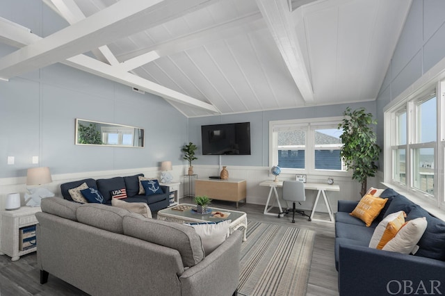 living area with lofted ceiling with beams, dark wood-style flooring, and a decorative wall