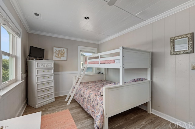 bedroom with dark wood-style floors, visible vents, and crown molding