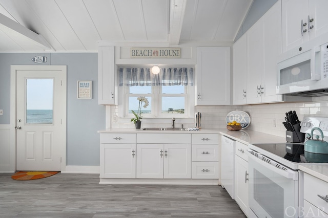 kitchen featuring light countertops, white appliances, and white cabinetry