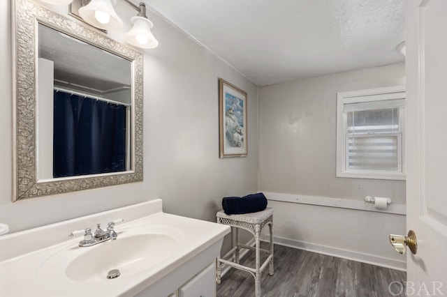 full bathroom featuring a textured ceiling, wood finished floors, and vanity