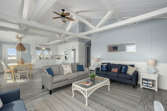 living room featuring visible vents, a ceiling fan, wood finished floors, beamed ceiling, and high vaulted ceiling