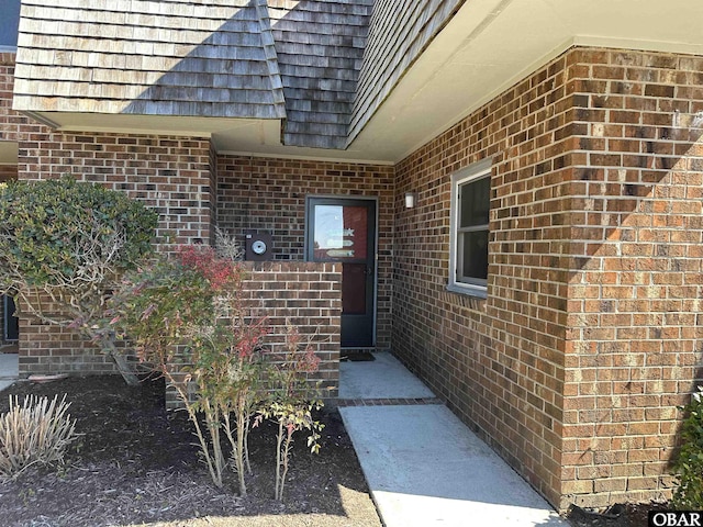 entrance to property featuring brick siding