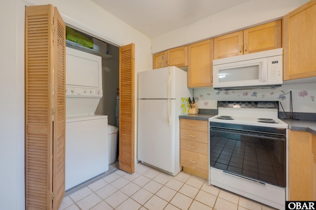 kitchen featuring light tile patterned floors, stacked washer and dryer, white appliances, and light brown cabinetry