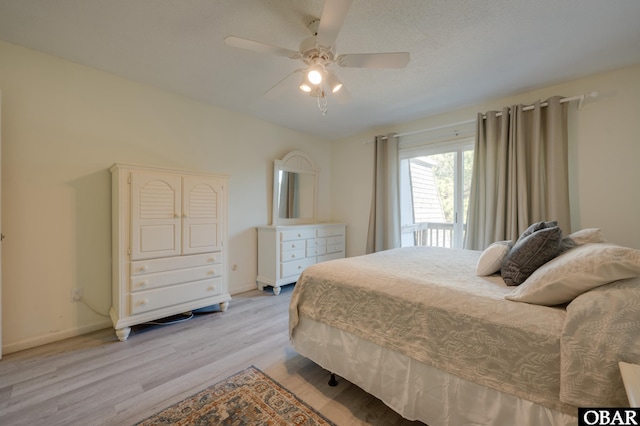 bedroom with light wood-type flooring, ceiling fan, a textured ceiling, and baseboards