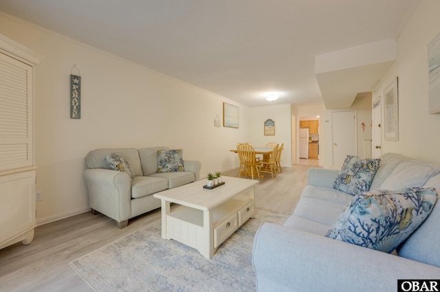 living area featuring baseboards and light wood-style floors