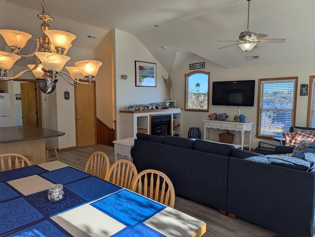 dining room featuring vaulted ceiling, wood finished floors, visible vents, and a ceiling fan