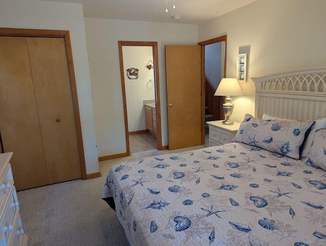 bedroom with connected bathroom, baseboards, a closet, and light colored carpet