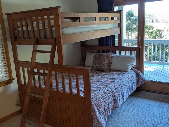 carpeted bedroom featuring access to outside and baseboards