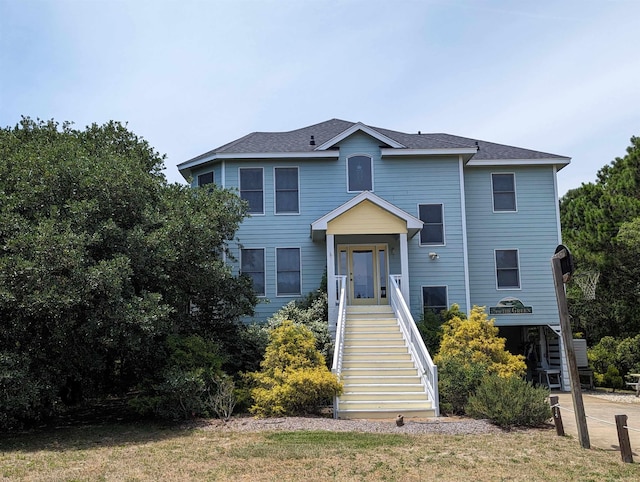 view of front of house with stairs and roof with shingles