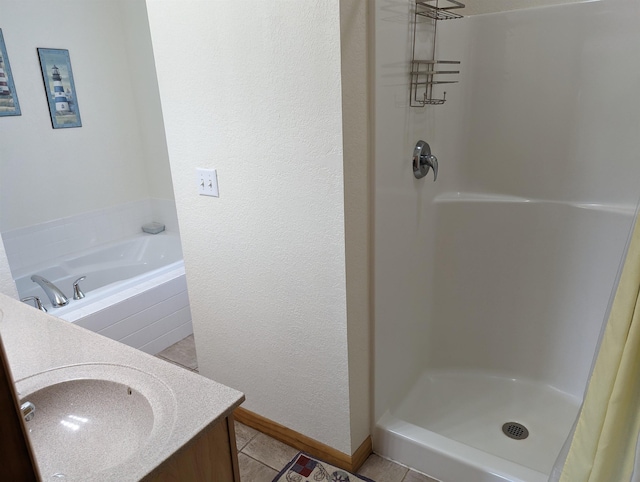 bathroom featuring a textured wall, tile patterned flooring, vanity, baseboards, and a shower stall