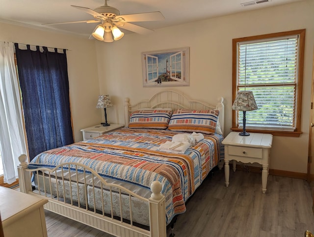 bedroom with a ceiling fan, visible vents, baseboards, and dark wood-style flooring