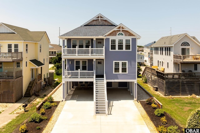 1726 Bobby Lee Trl Lot 5, Kill Devil Hills, NC 27948 - rear view of property with a carport, concrete driveway, a balcony, roof with shingles, and stairway
