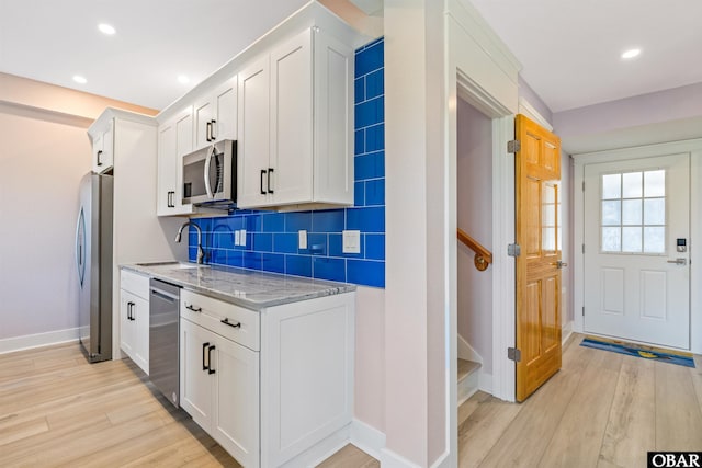1726 Bobby Lee Trl Lot 5, Kill Devil Hills, NC 27948 - kitchen featuring appliances with stainless steel finishes, light wood-style floors, white cabinetry, light stone countertops, and baseboards
