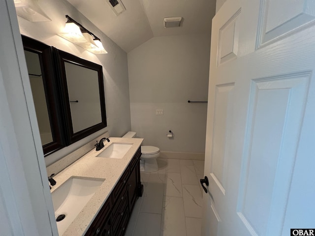 bathroom featuring vaulted ceiling, marble finish floor, a sink, and toilet