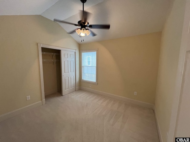 unfurnished bedroom with a closet, light colored carpet, vaulted ceiling, ceiling fan, and baseboards