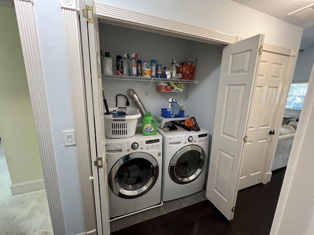 laundry area with washer and dryer, laundry area, and dark tile patterned flooring