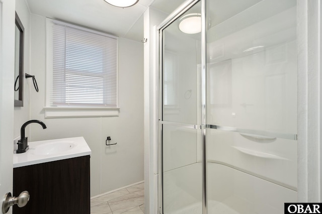 bathroom featuring marble finish floor, a stall shower, and vanity