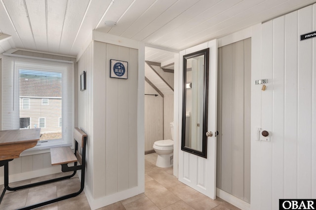 bathroom featuring wood ceiling, wooden walls, toilet, and tile patterned floors